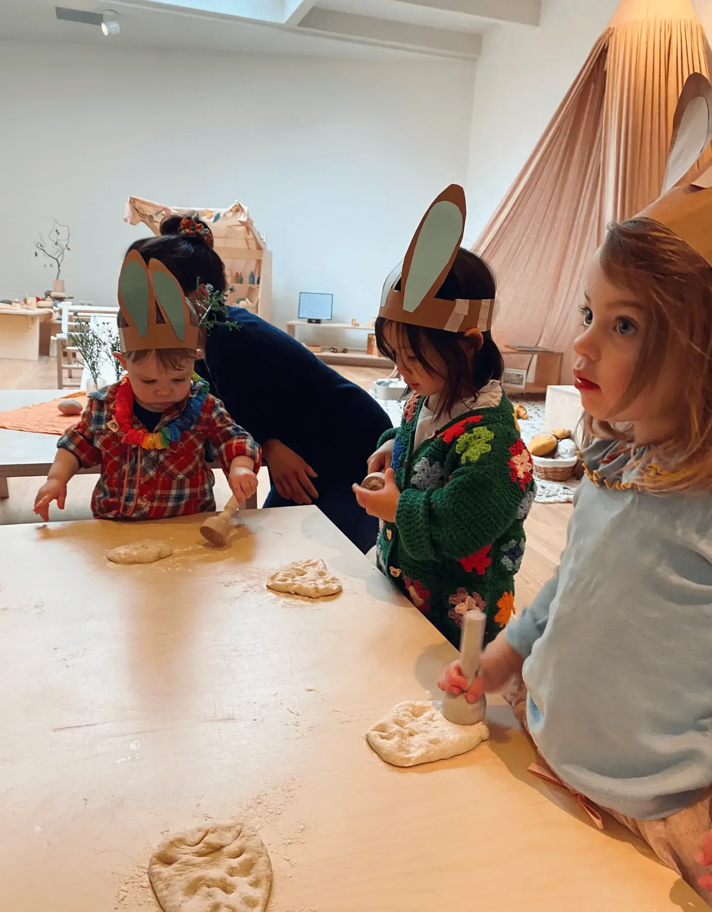 Toddlers dressed up and kneading bread together